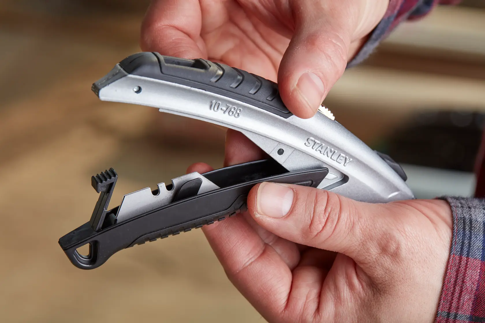 Photo of STANLEY 0-10-788 utility knife being opened to show blade storage feature.