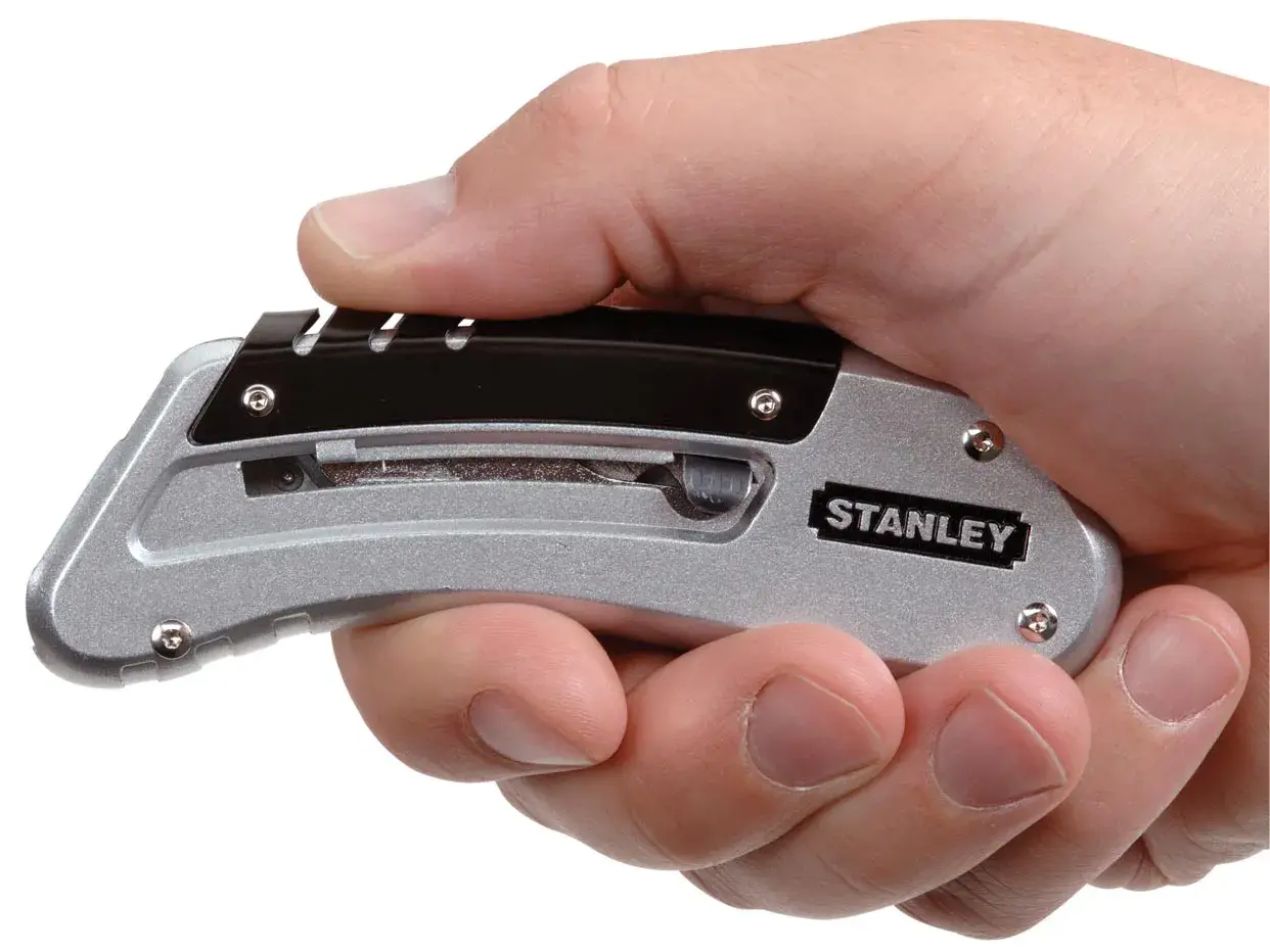 Photo of STANLEY 0-10-810 utility knife with silver and black handle, compactly held in a hand, side angle.