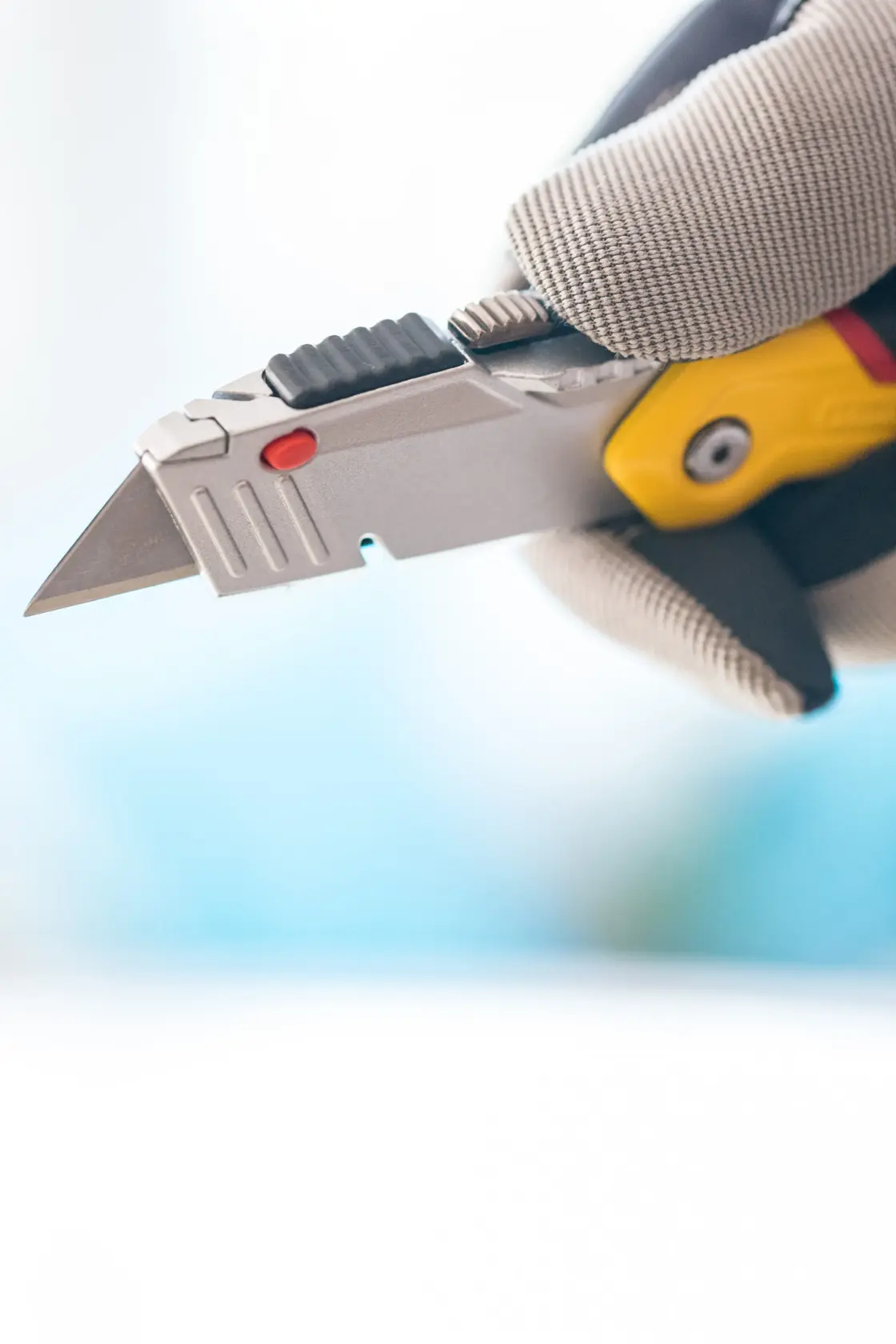 STANLEY 0-10-825 utility knife with retractable blade, shown in gloved hand, close-up angle.