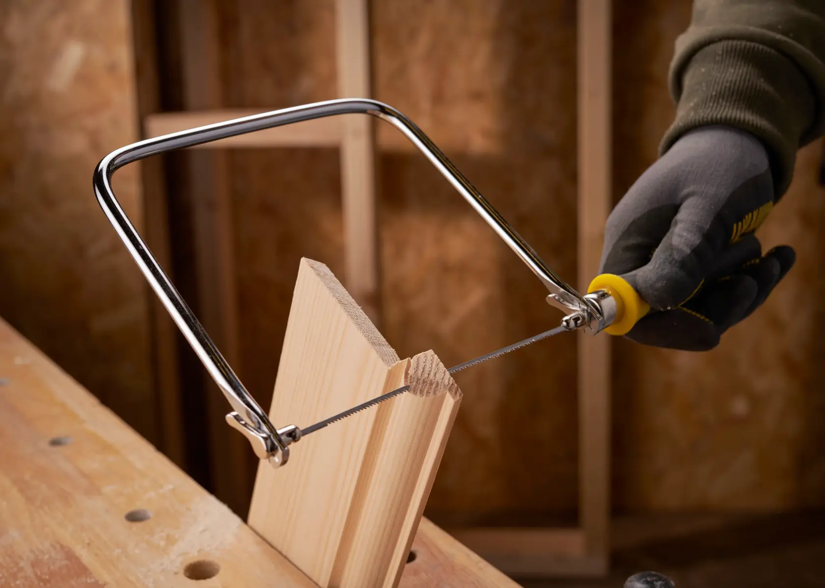 STANLEY 0-15-106 coping saw used to cut wood, close-up photography in workshop setting.