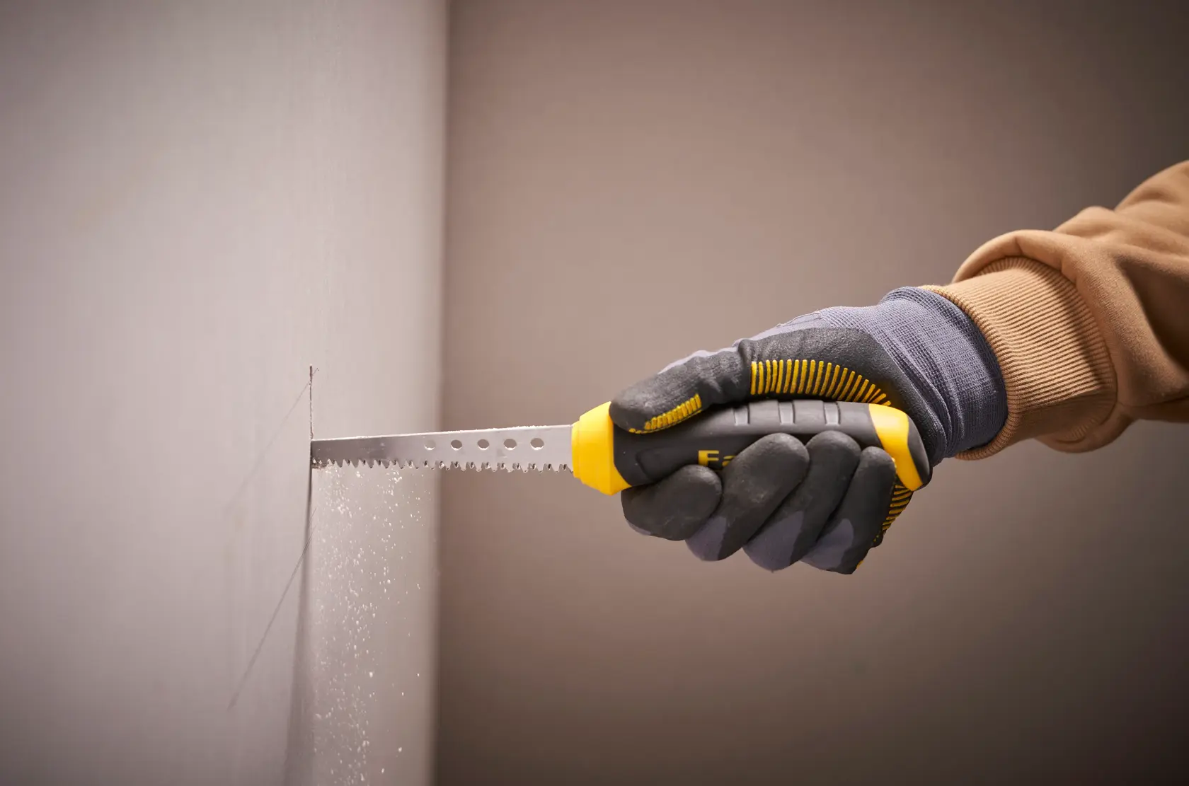 STANLEY 0-20-556 drywall saw with yellow and black handle, cutting wall, side view.