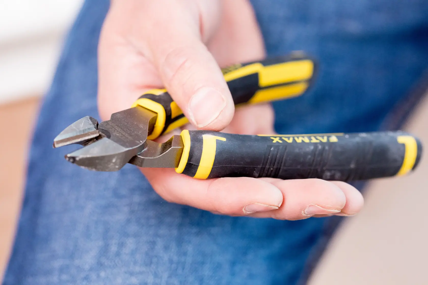 Photo of STANLEY 0-89-858 diagonal cutting pliers with black and yellow handle, held in hand.
