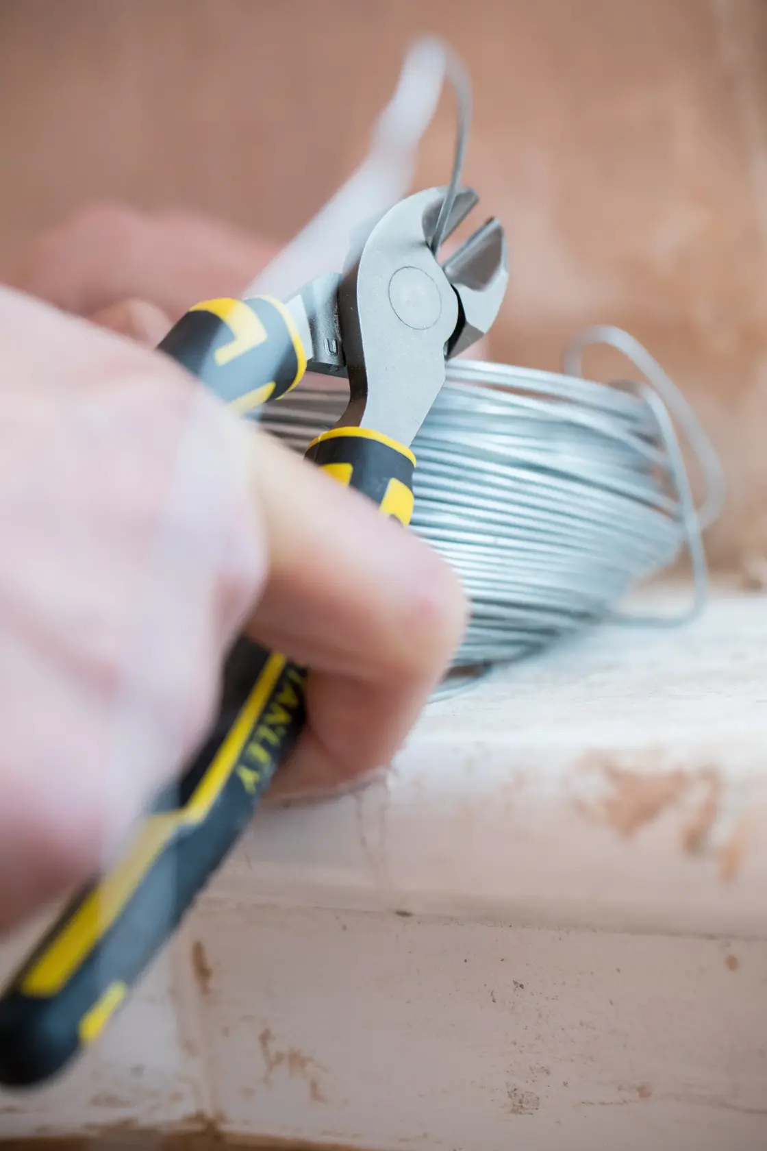 STANLEY 0-89-859 diagonal cutting pliers close-up cutting wire, black and yellow ergonomic handle.