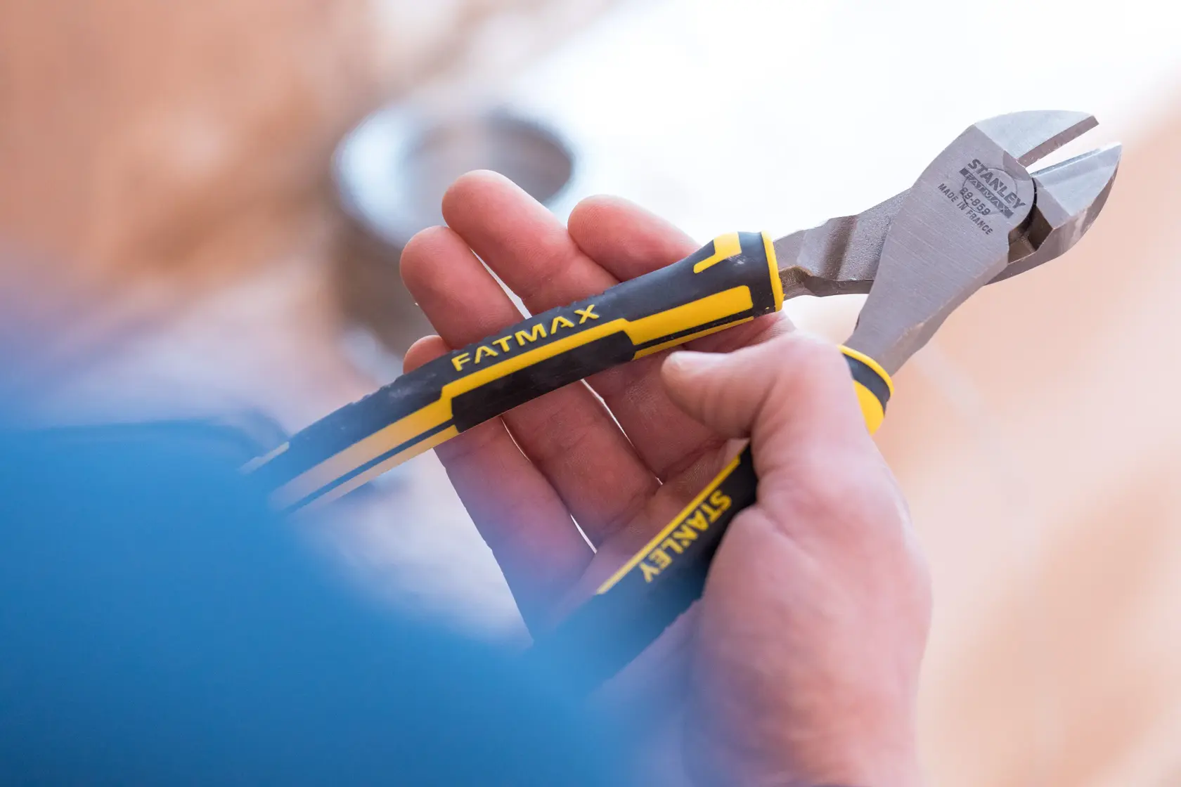STANLEY 0-89-859 diagonal cutting pliers with black and yellow FATMAX handles held in hand.