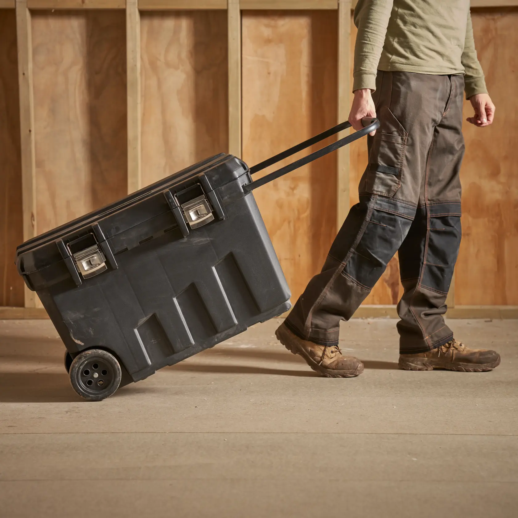 STANLEY 1-92-978 rolling tool box being pulled by a person in workwear, indoor setting.