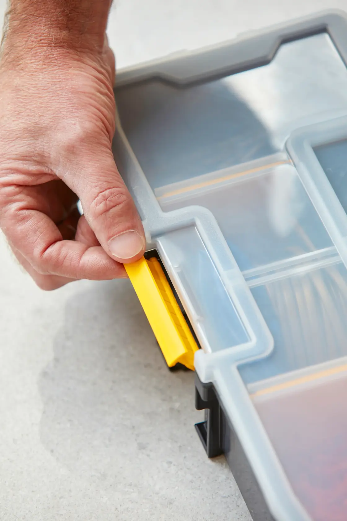 STANLEY 1-94-745 organiser close-up, hand opening yellow latch on clear plastic lid.