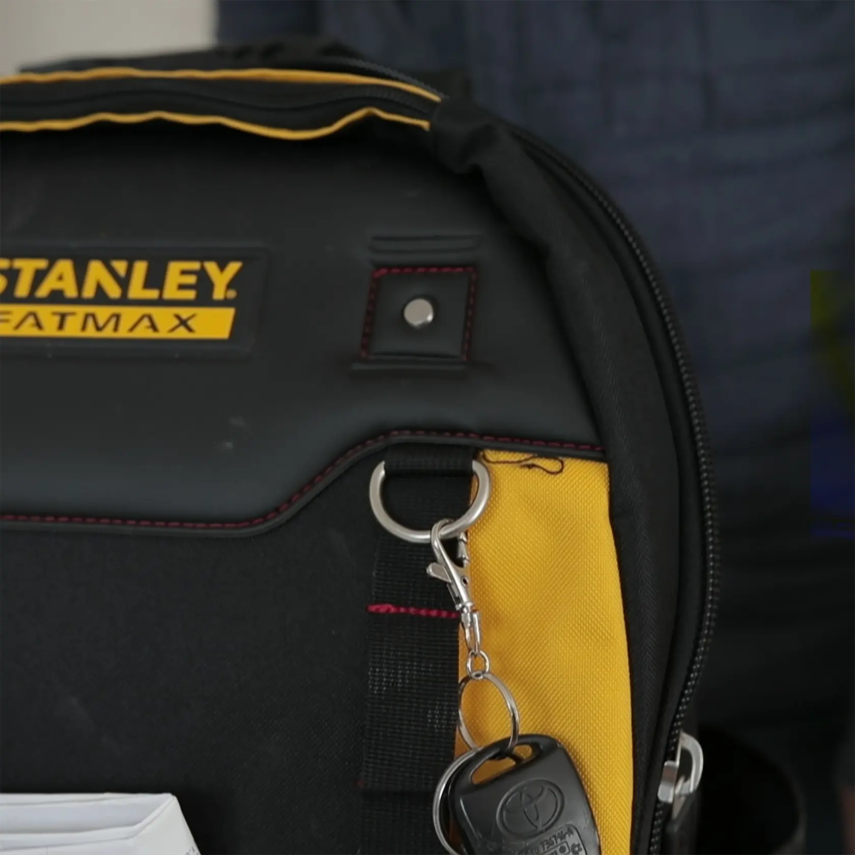 STANLEY 1-95-611 black and yellow tool bag, close-up side view with keyring attached. Photography.