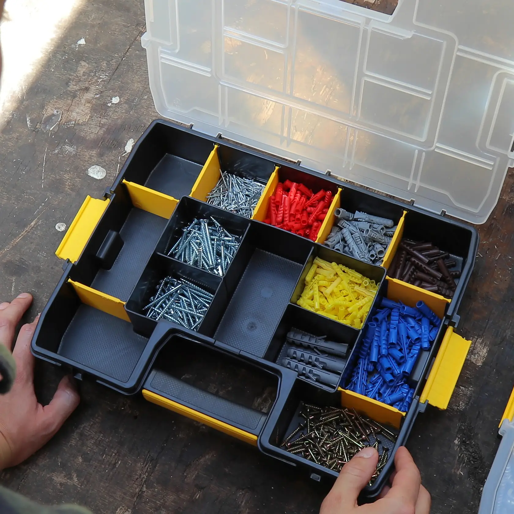 Photo of STANLEY 1-97-483 organizer box with assorted screws and colored wall plugs, top view.