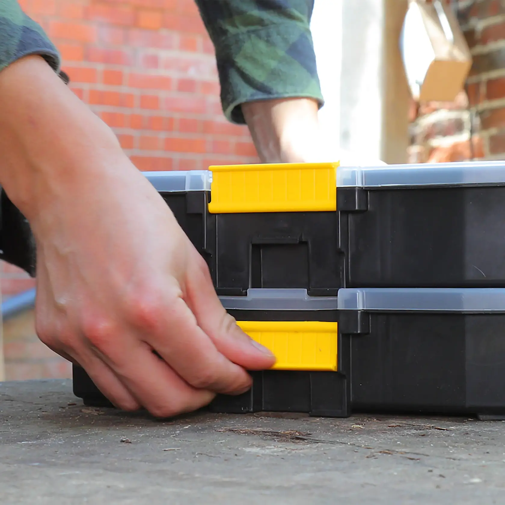 STANLEY 1-97-483 black and yellow toolbox photography, close-up of hand opening latch outdoors.