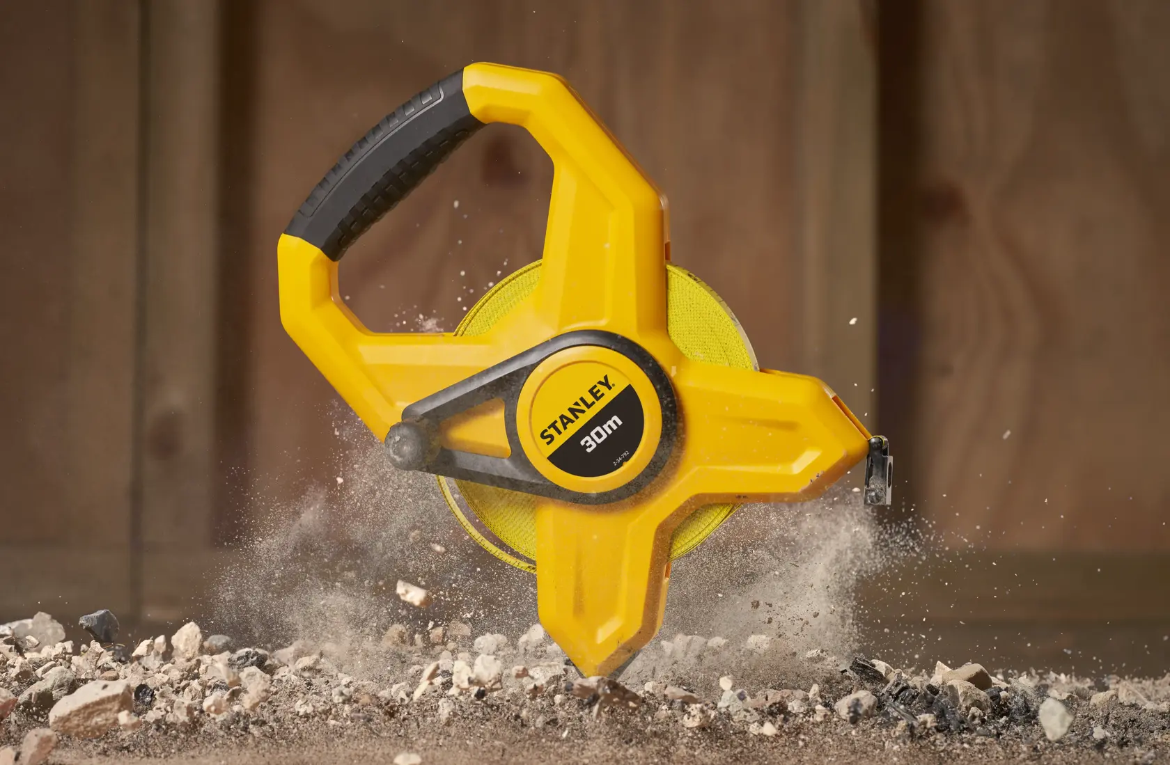 STANLEY 2-34-792 30m yellow open reel measuring tape on construction site, close-up photography.