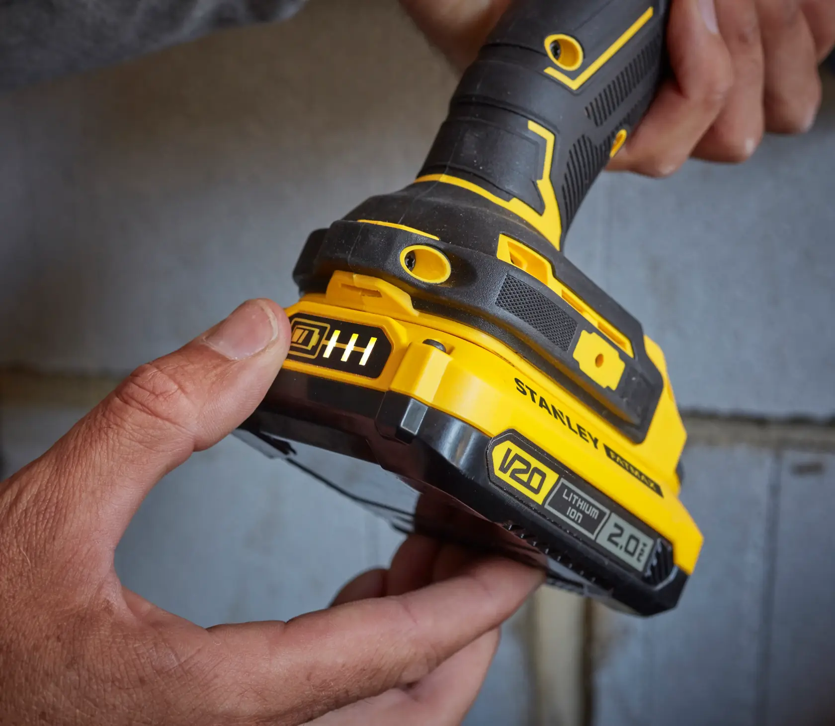 Photo of STANLEY SFMCD721D2K cordless drill base with V20 lithium-ion 2.0Ah battery held by hands.