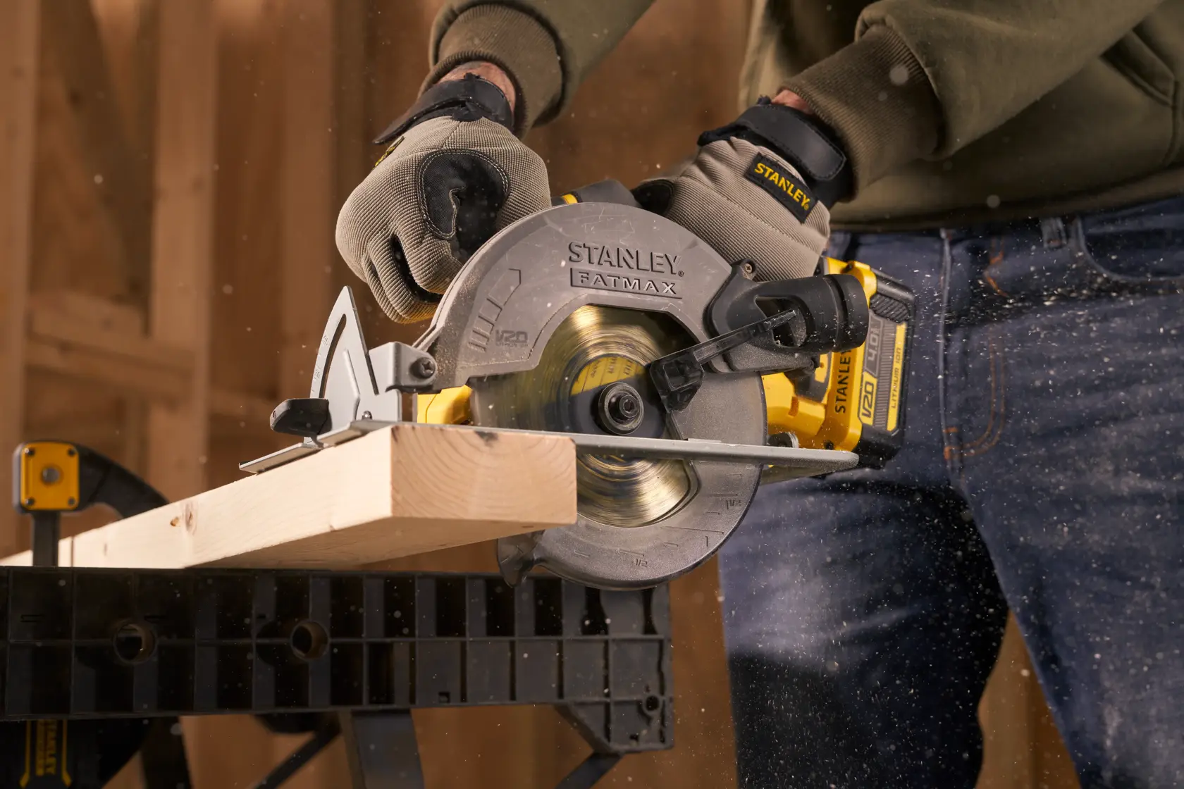 Photo of STANLEY SFMCS500M1K circular saw cutting wood, held by person wearing gloves during woodworking.