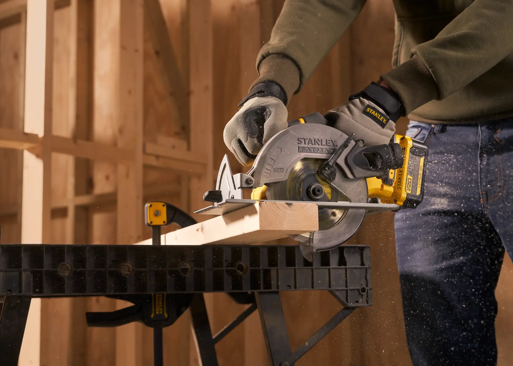 STANLEY SFMCS500M1K circular saw cutting wood, used by a person wearing gloves in a workshop setting.
