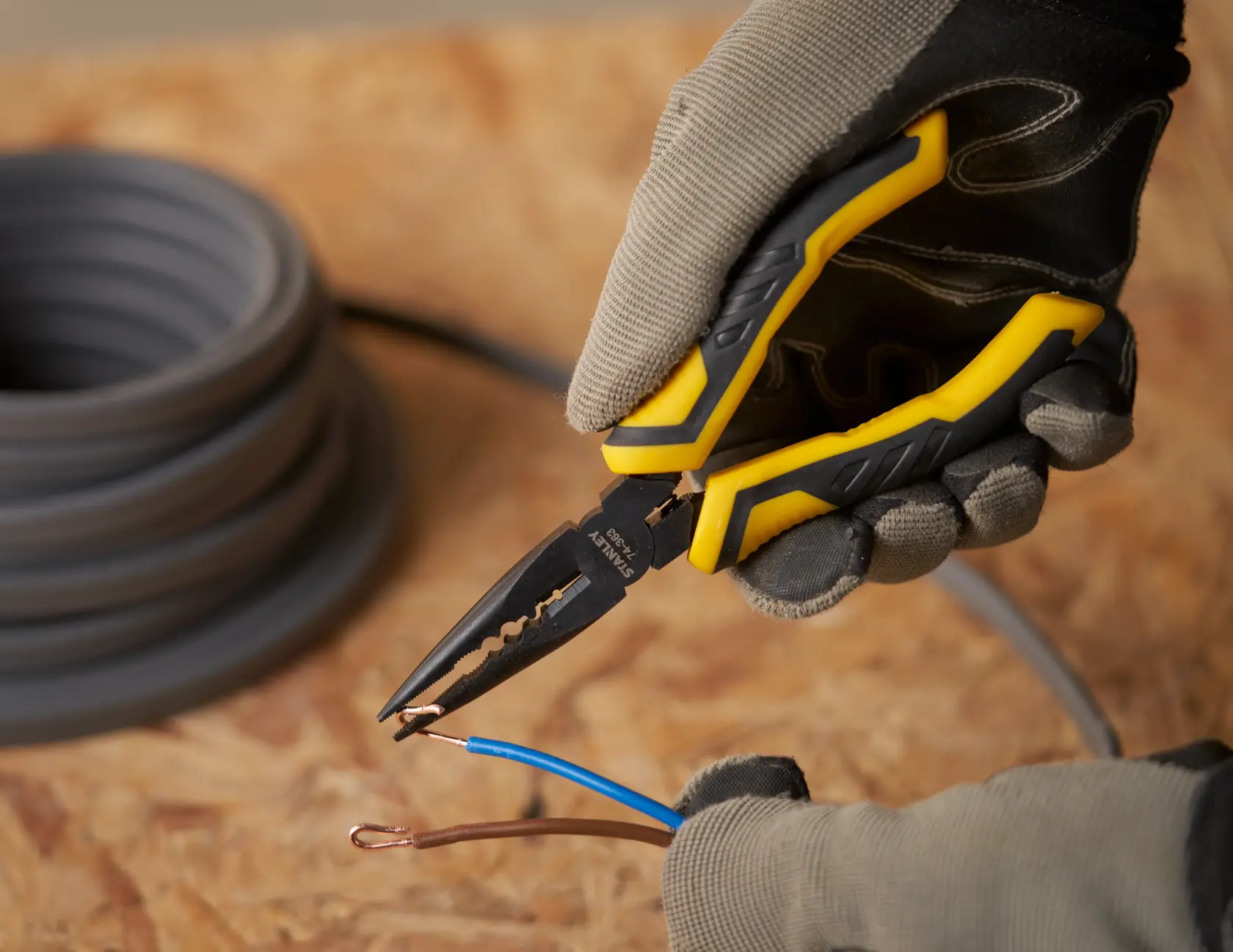 STANLEY STHT0-74364 long nose pliers cutting copper wire, yellow and black handle, close-up action.