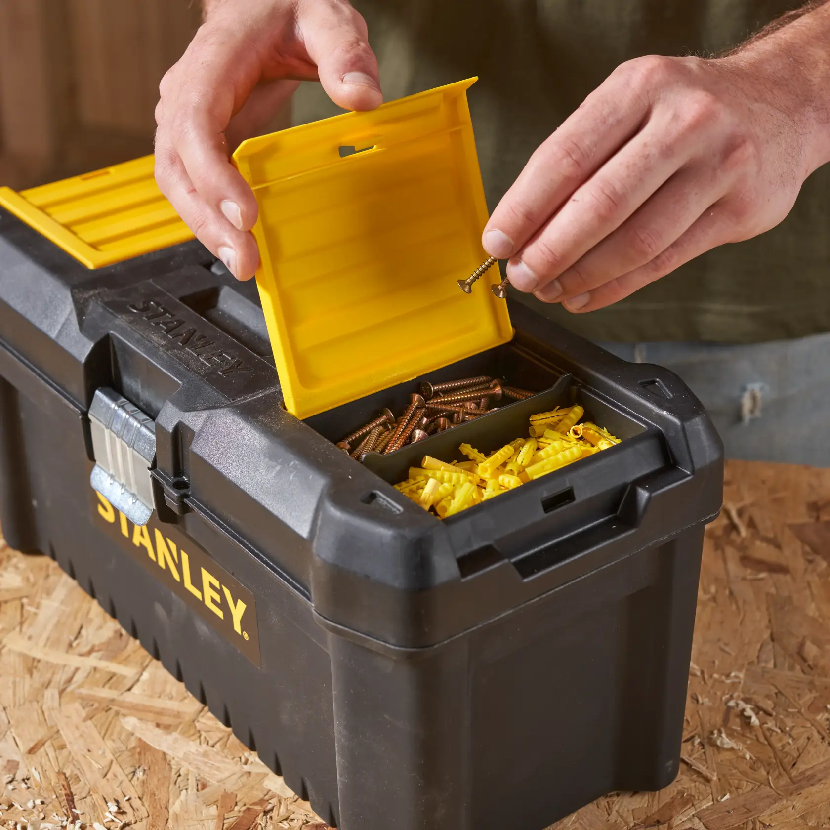 STANLEY STST1-75518-KR toolbox with yellow compartment lid open, storing screws and wall plugs, close-up photo.