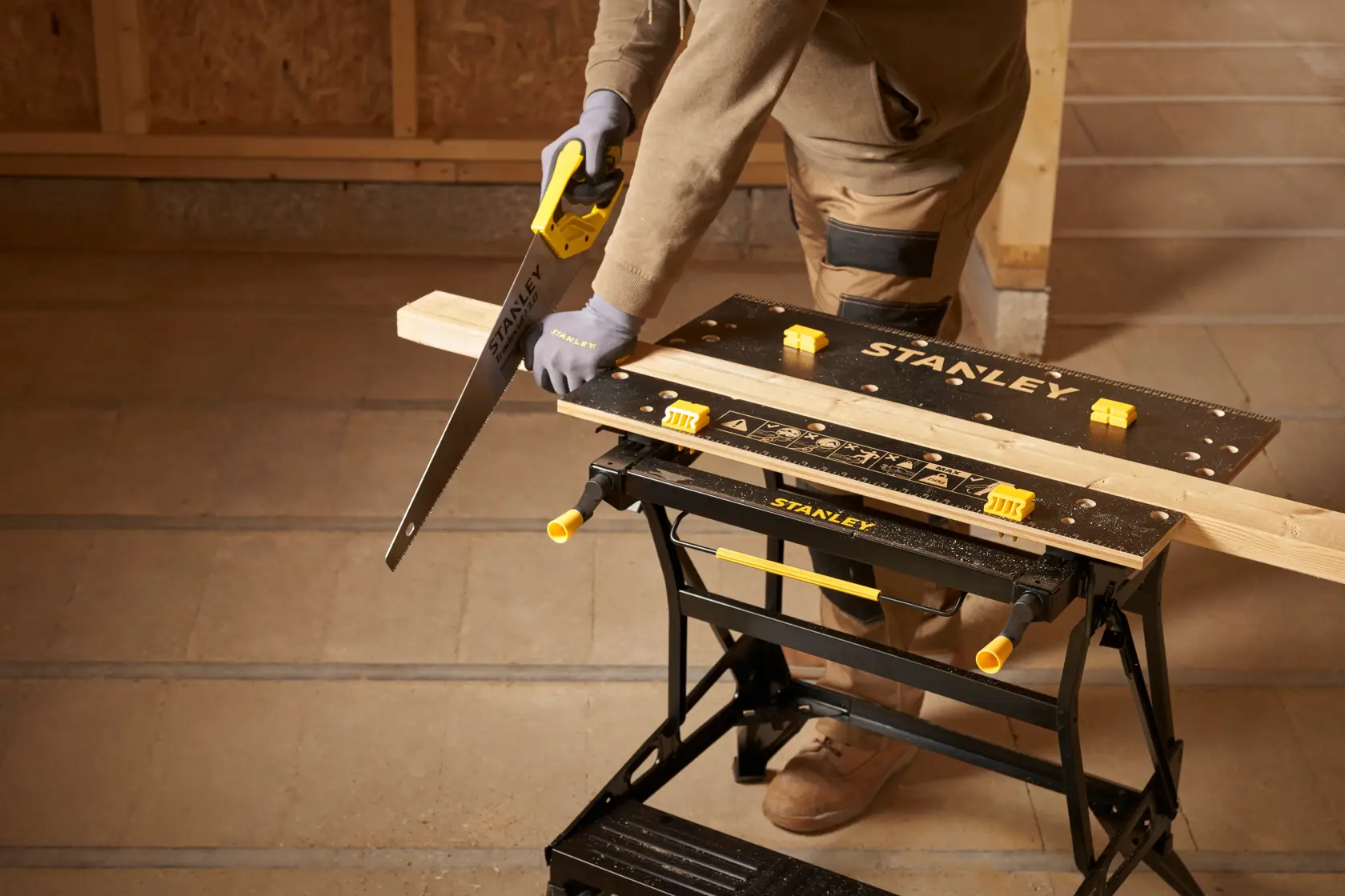 Photo of STANLEY STST83800-1 workbench used for woodworking, black tabletop with yellow clamps, workshop setting.