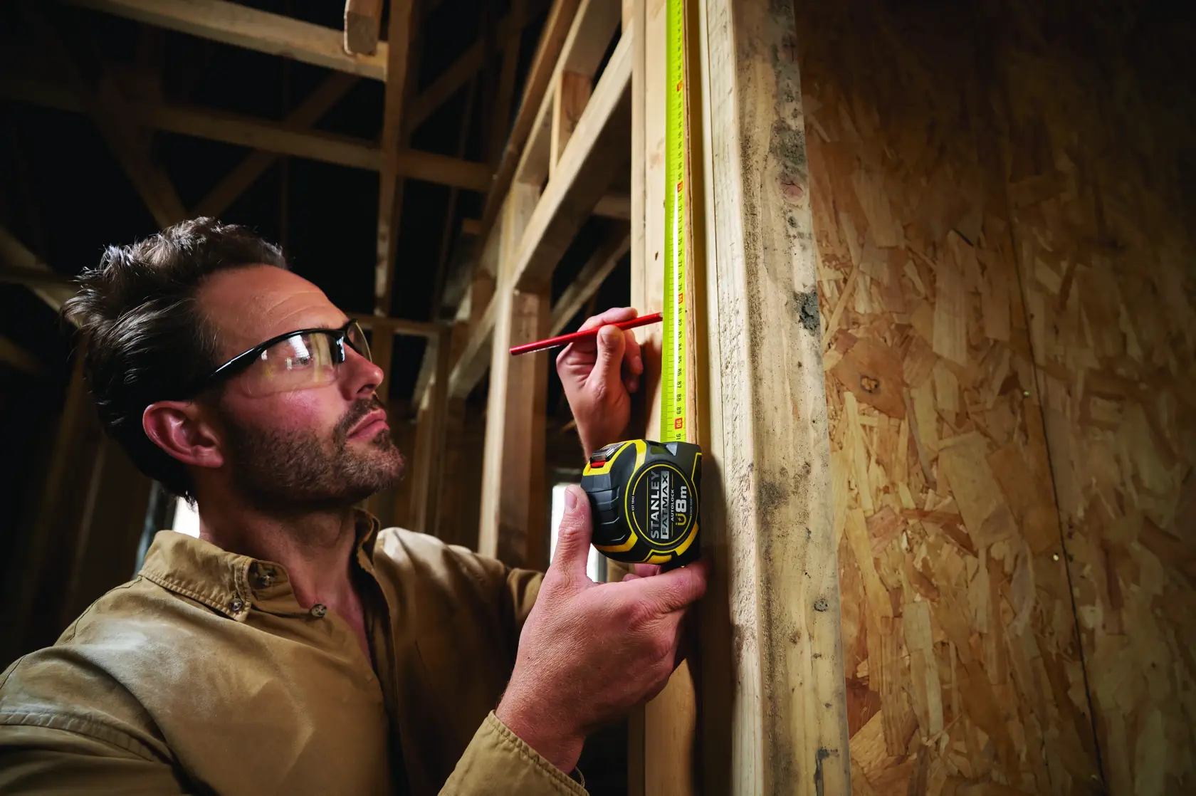 Photo of STANLEY XTHT0-33501 tape measure used to measure wooden frame during construction.